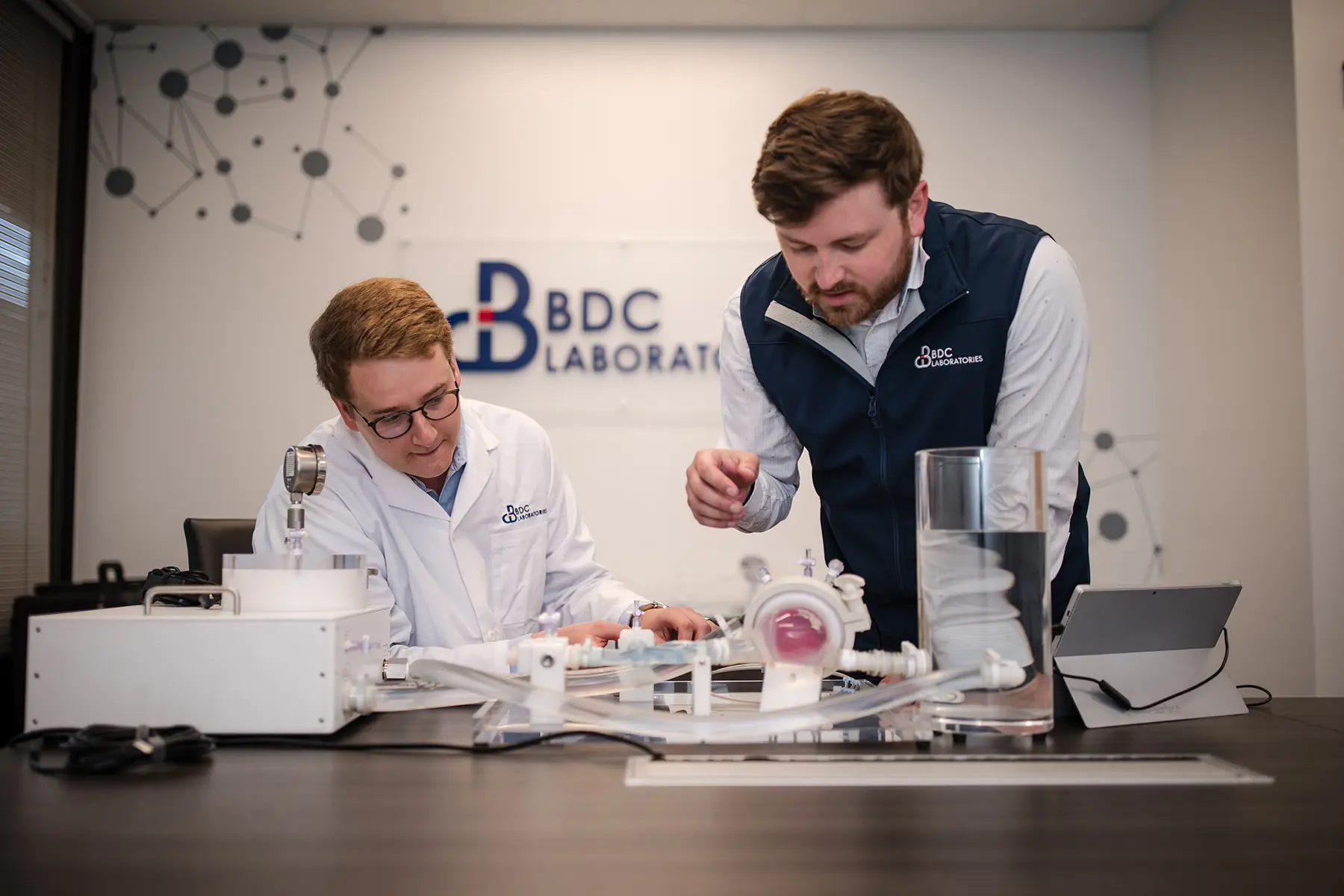 Team members examining BDC Labs equipment on a table